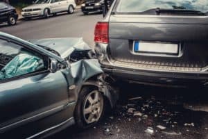 A car is badly damaged after rear ending a minivan