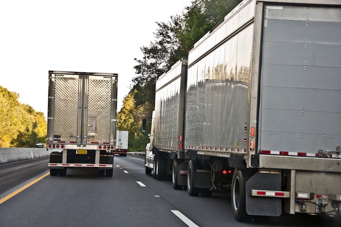 A Convoy of 18-wheelers rolling on down the highway.