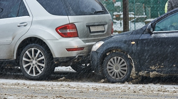 Unable to stop on the icy road, a driver rear-ends an SUV