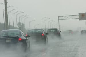 A heavy rainstorm on busy highway makes travel dangerous