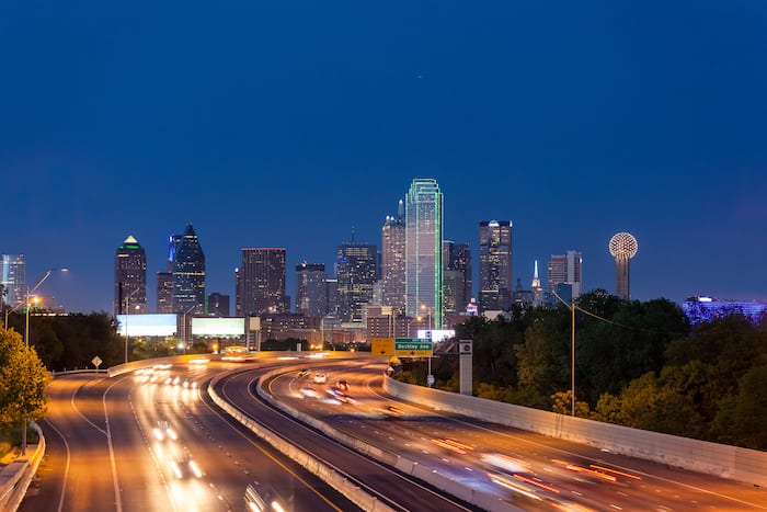 A freeway leads to the Dallas downtown skyline at night, Texas