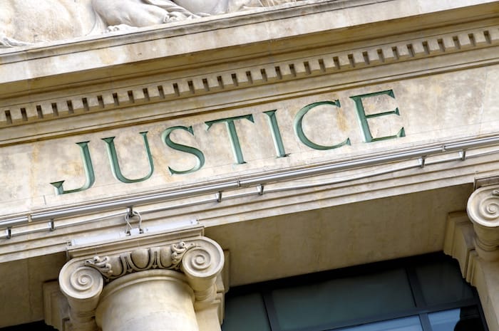 The Word Justice carved in the marble at a courthouse