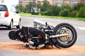 A damaged motorcycle lies in the street after an accident