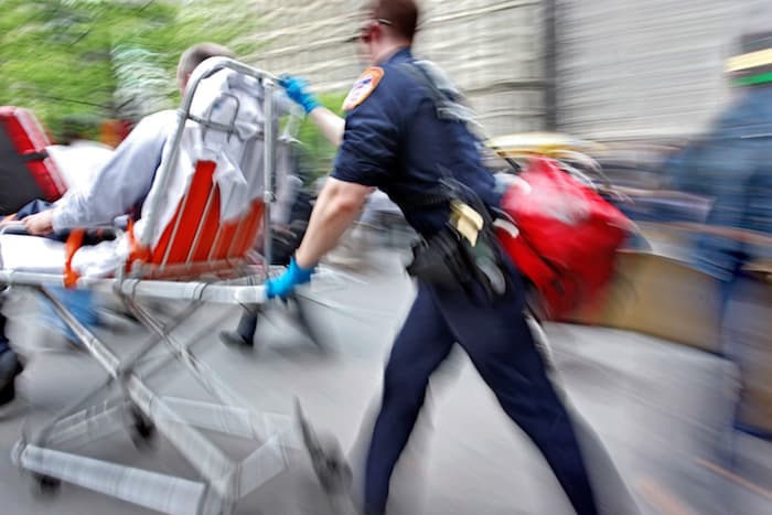 Paramedics wheel a victim to an ambulance after an accident