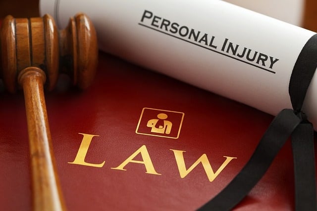 A gavel and Personal injury scroll sit atop a law book