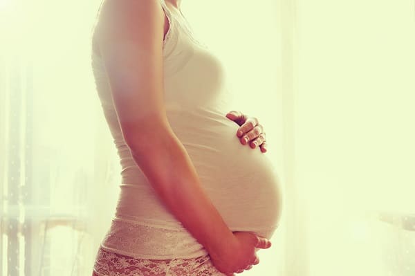 Pregnant woman touching her belly with hands