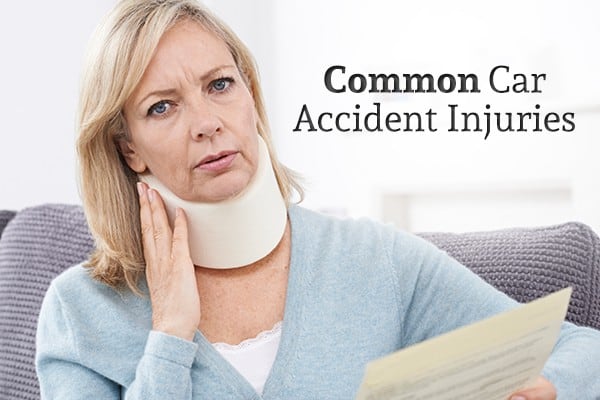 A woman with a neck brace holds a piece of paper beside the words "Common Car Accident Injuries"