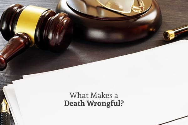 A gavel is sitting near a white piece of legal paper on a desk. Underneath the gavel are the words, what makes a death wrongful.