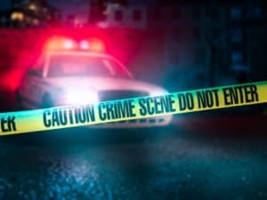 Crime scene tape is in front of a police car.