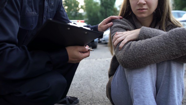 A police officer comforting a girl after a crime.
