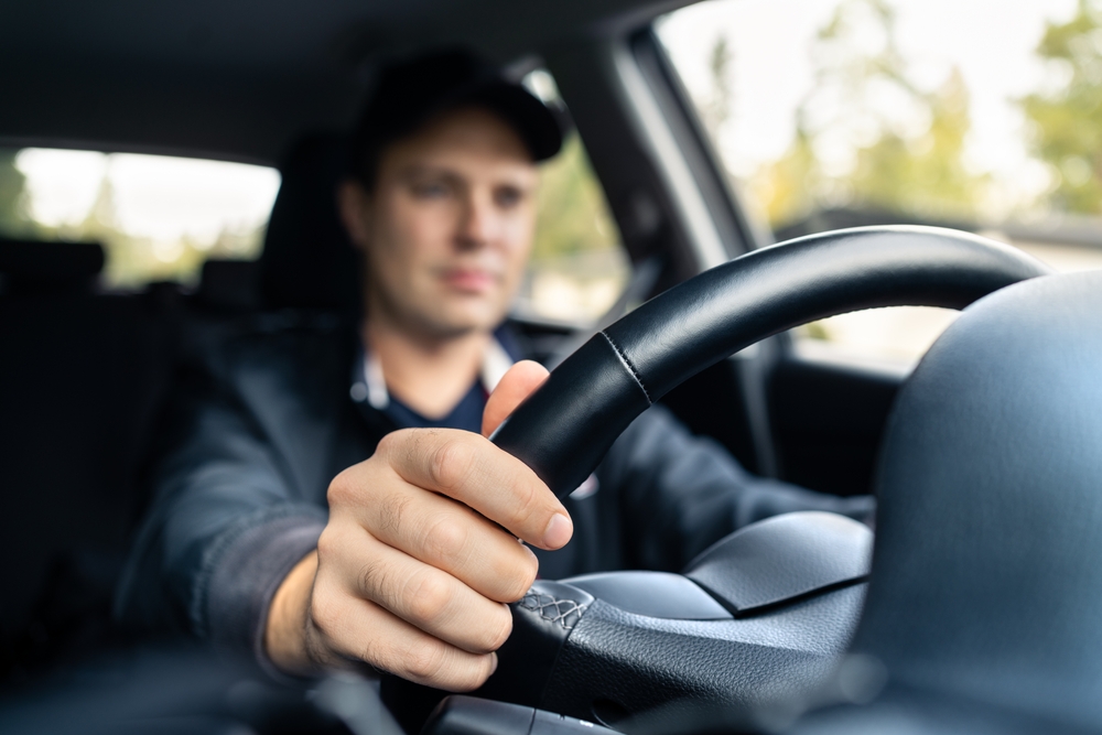 Man driving a vehicle with both hands on the wheel, representing everyday driver behavior included in DFW car accident data.