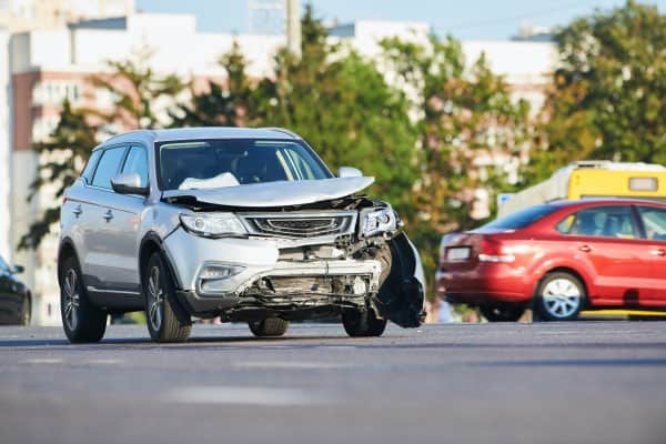 A car accident involving a silver SUV with a smashed in hood.