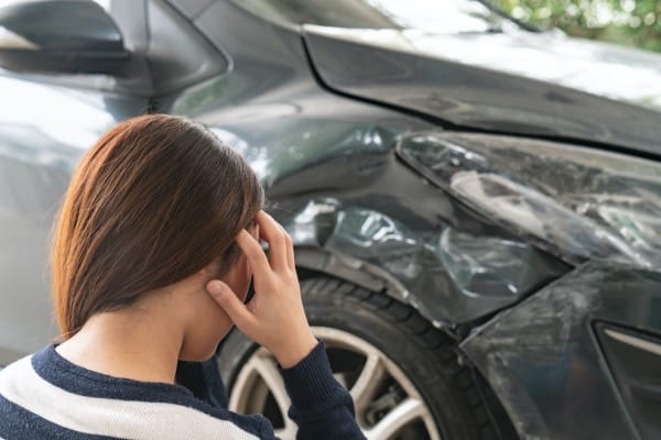 A lady holding her head in distress after a hit and run accident.