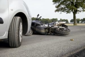 A car has crashed into a motorcycle.
