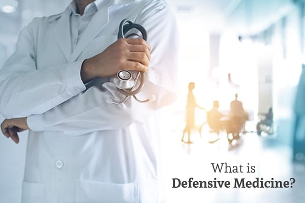 A doctor has his arms crossed with patients in the background along with the words, what is defensive medicine.