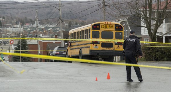 An police officer overlooking the cleanup of a school bus accident.