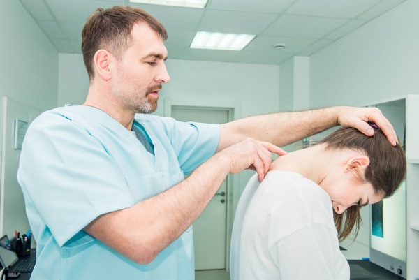 A doctor checking the spinal column of his patient.