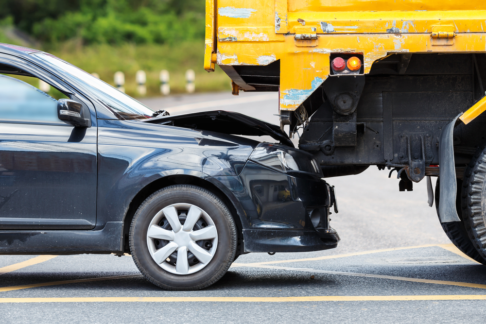 Passenger car lodged under the back of a commercial truck after a rear-end collision, illustrating common causes of serious crashes in Texas.