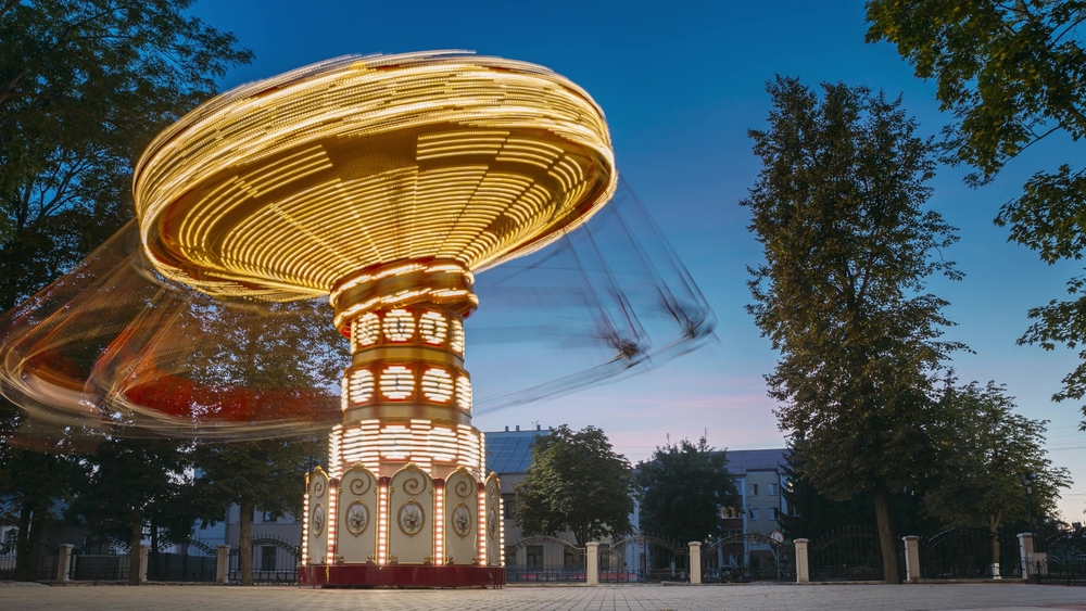 Illuminated swing ride spinning at night in an amusement park in Arlington