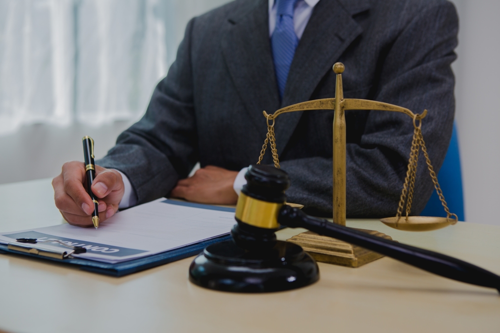 Arlington spinal cord injury attorney reviewing a client’s case documents with legal symbols on desk