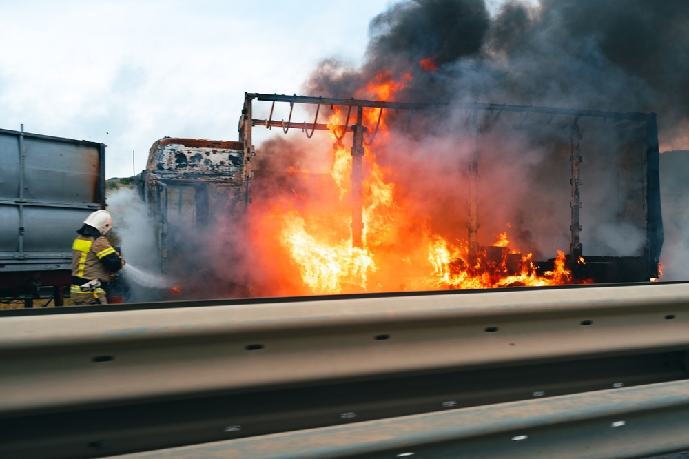 A car on fire after an accident, symbolizing the causes of burn injury claims