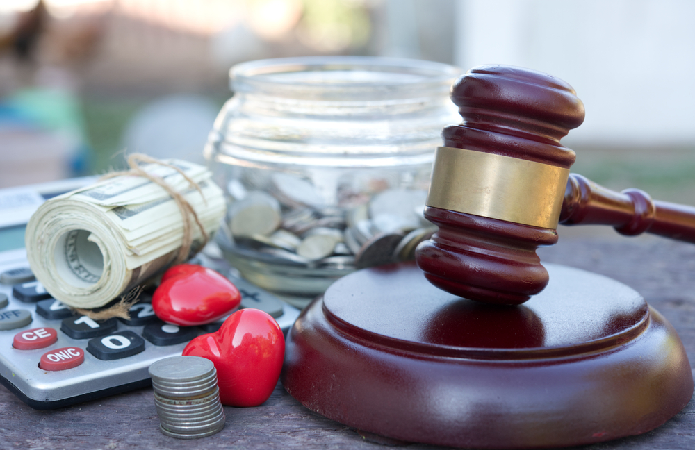 A calculator and a jar with money next to a gavel, symbolizing costs and fees for a burn injury claim