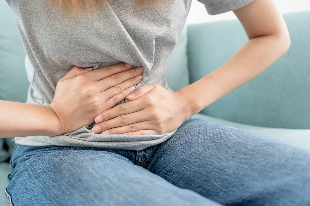 Person clutching their stomach in pain due to food poisoning symptoms
