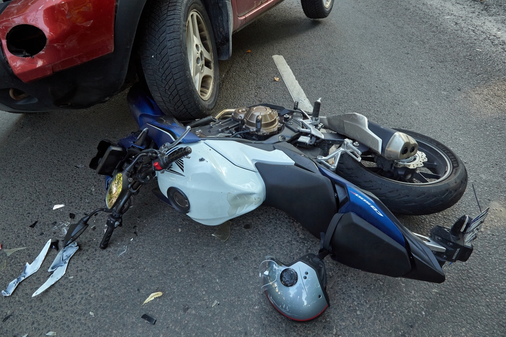 Motorcycle damaged under a vehicle after a collision, illustrating shared fault in a Texas motorcycle accident