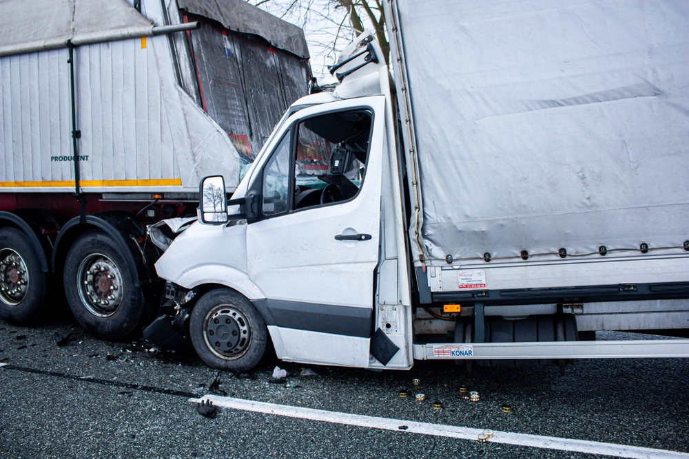 White van damaged in a collision with a commercial trailer, highlighting the importance of evidence in Texas truck accident investigations.
