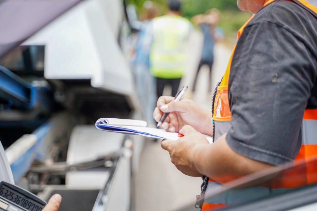 Close-up of an investigator taking notes at the scene of a crash, illustrating how to file a truck accident lawsuit.