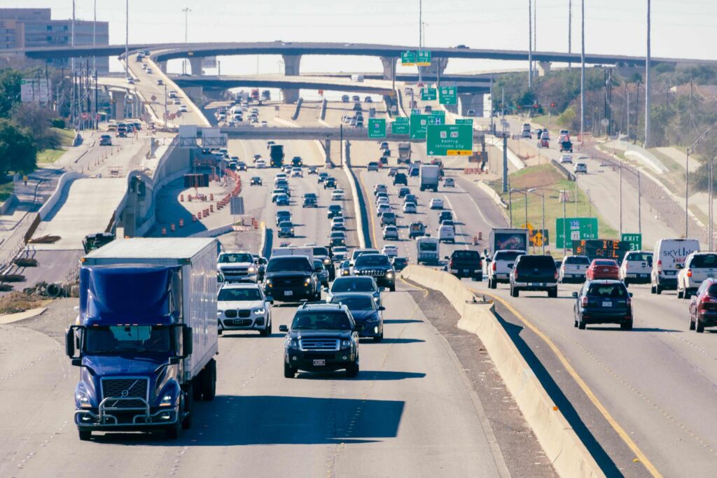 Heavy traffic on a multi-lane Texas freeway where a truck driver may leave the scene of an accident.