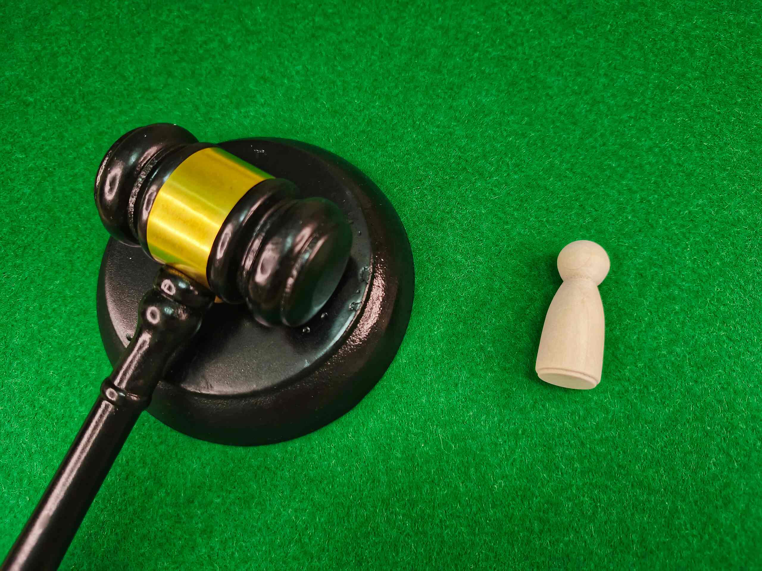 A wooden legal gavel next to a small white figure, representing the different kinds of damages you can sue for in Texas.