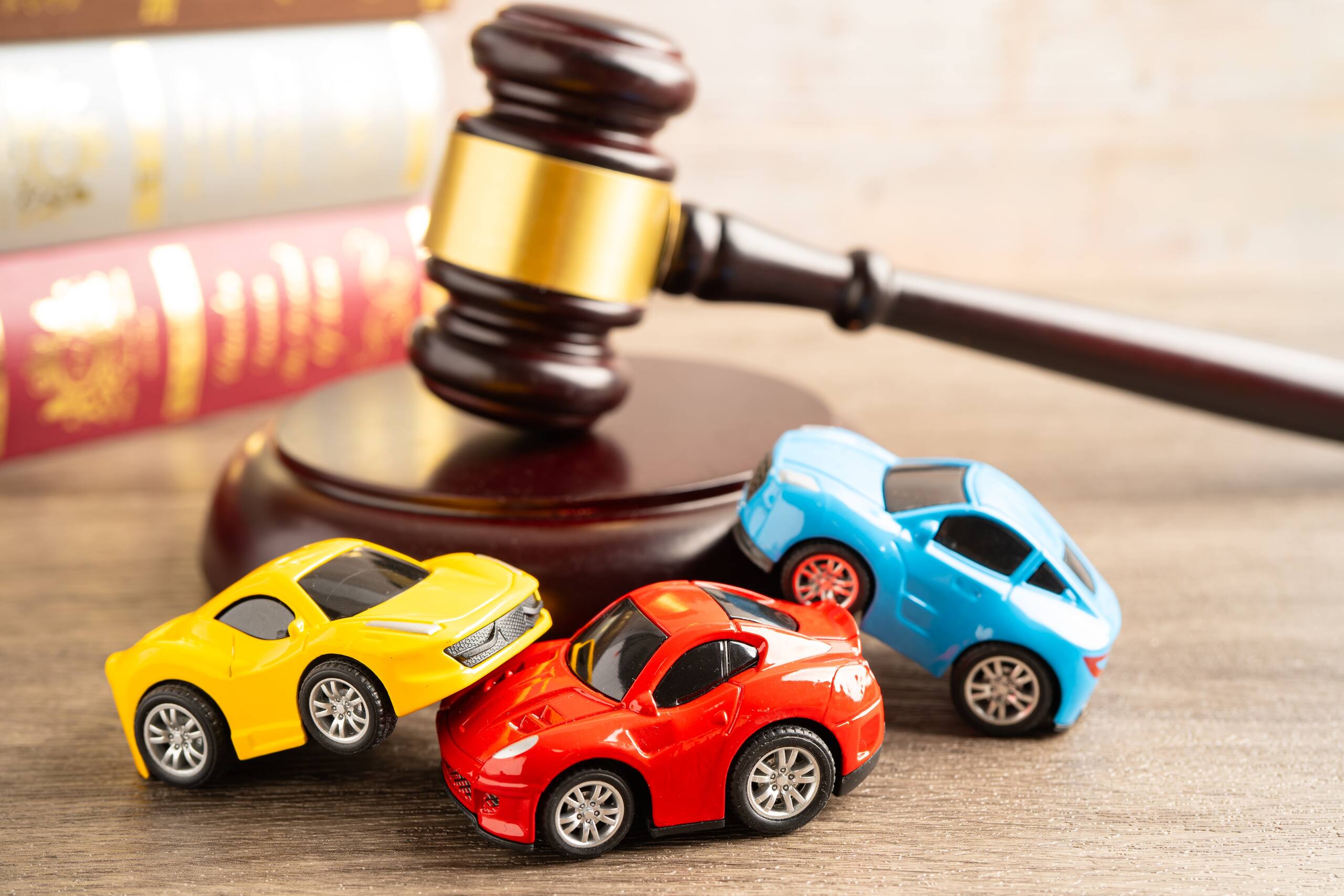 Legal representation for reopening a car accident claim in Arlington with toy cars and judge gavel symbolizing additional compensation after a Texas crash