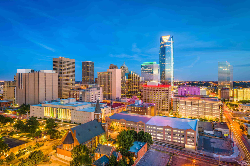 A downtown city street view with buildings including City Place Tower behind a row of autumn trees, providing local context for Oklahoma City Pedestrian Accident Attorneys.