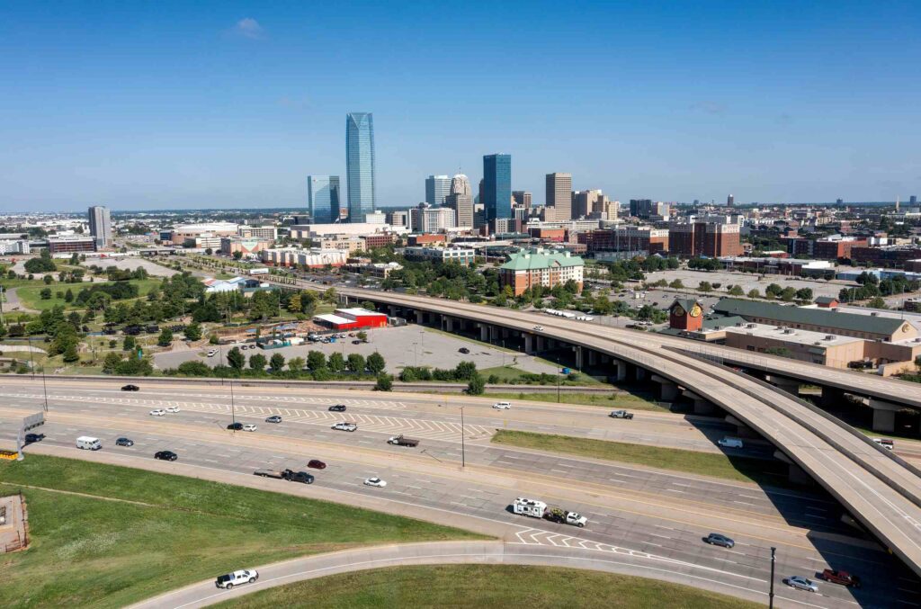 Aerial view of Oklahoma City highways and skyline, represented by Oklahoma City traumatic brain injury attorneys.