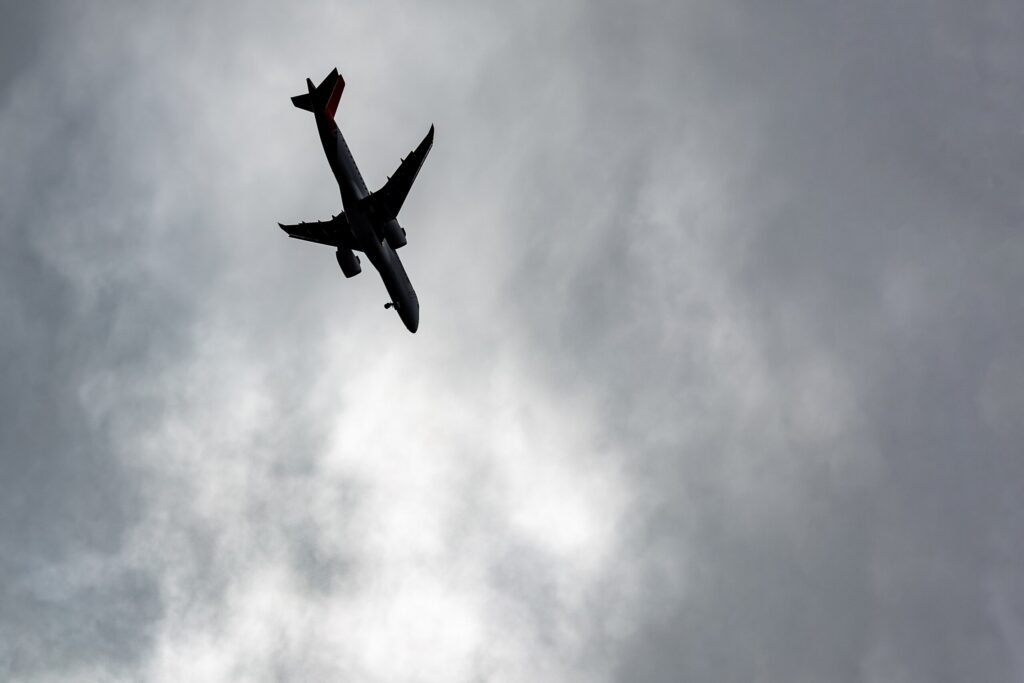 A silhouette of a passenger airplane flying through cloudy skies represents cases handled by Oklahoma City Airplane Accident Attorneys.