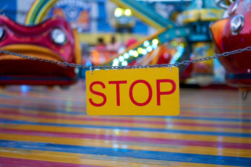 A yellow stop sign blocking a ride area illustrates safety hazards handled by Oklahoma City Amusement Park Accident Lawyers.