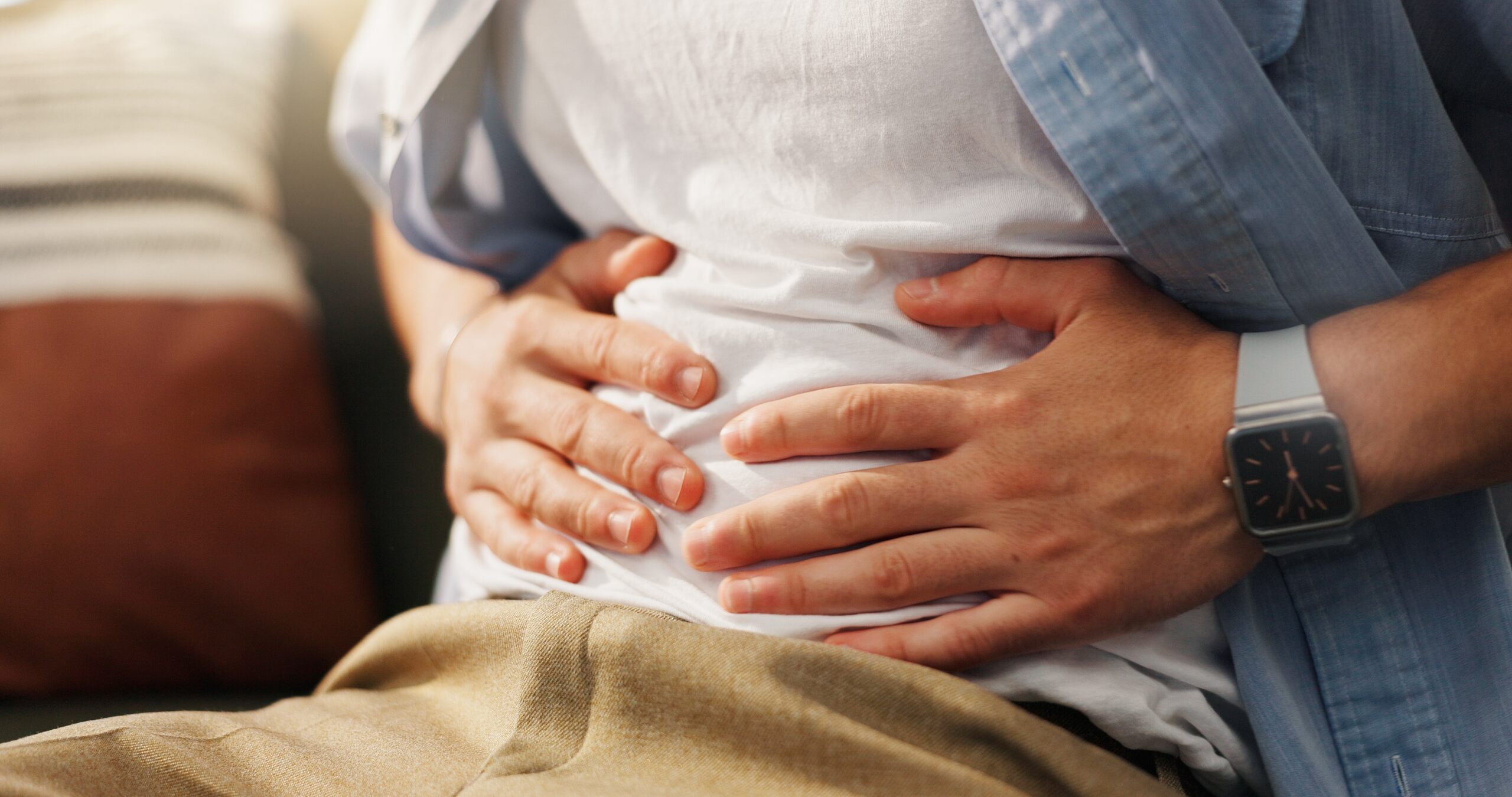 A person holding their stomach in pain illustrates symptoms handled by Oklahoma City Food Poisoning Lawyers.