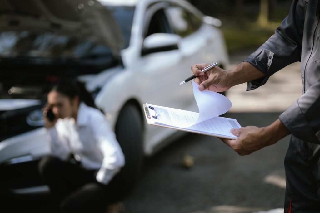 An inspector writing details on a clipboard helps determine who is at fault for an Oklahoma City rear-end accident.