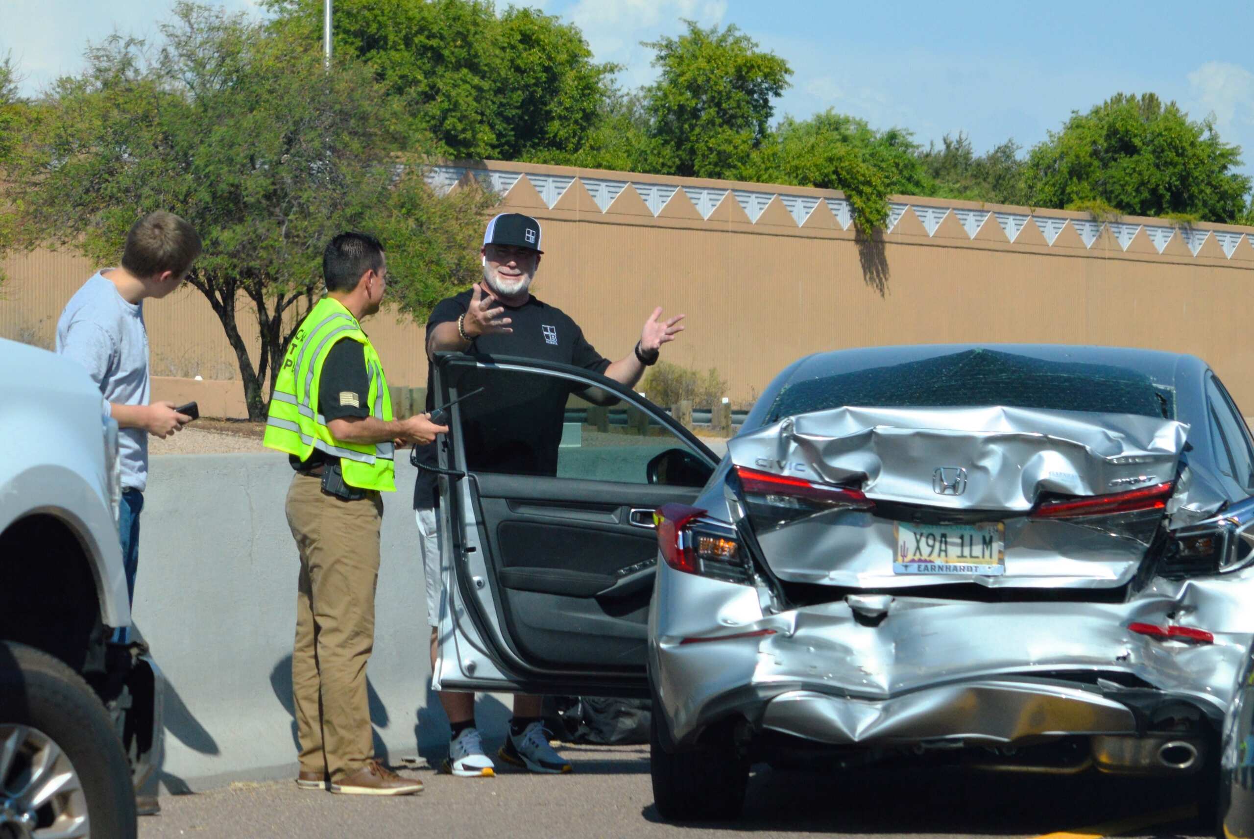 A driver gesturing while speaking to an officer next to a rear ended vehicle explains why get a medical exam after an OKC crash.